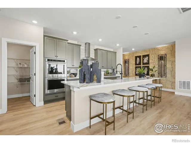 a dining hall with stainless steel appliances kitchen island granite countertop a dining table chairs and granite counter tops