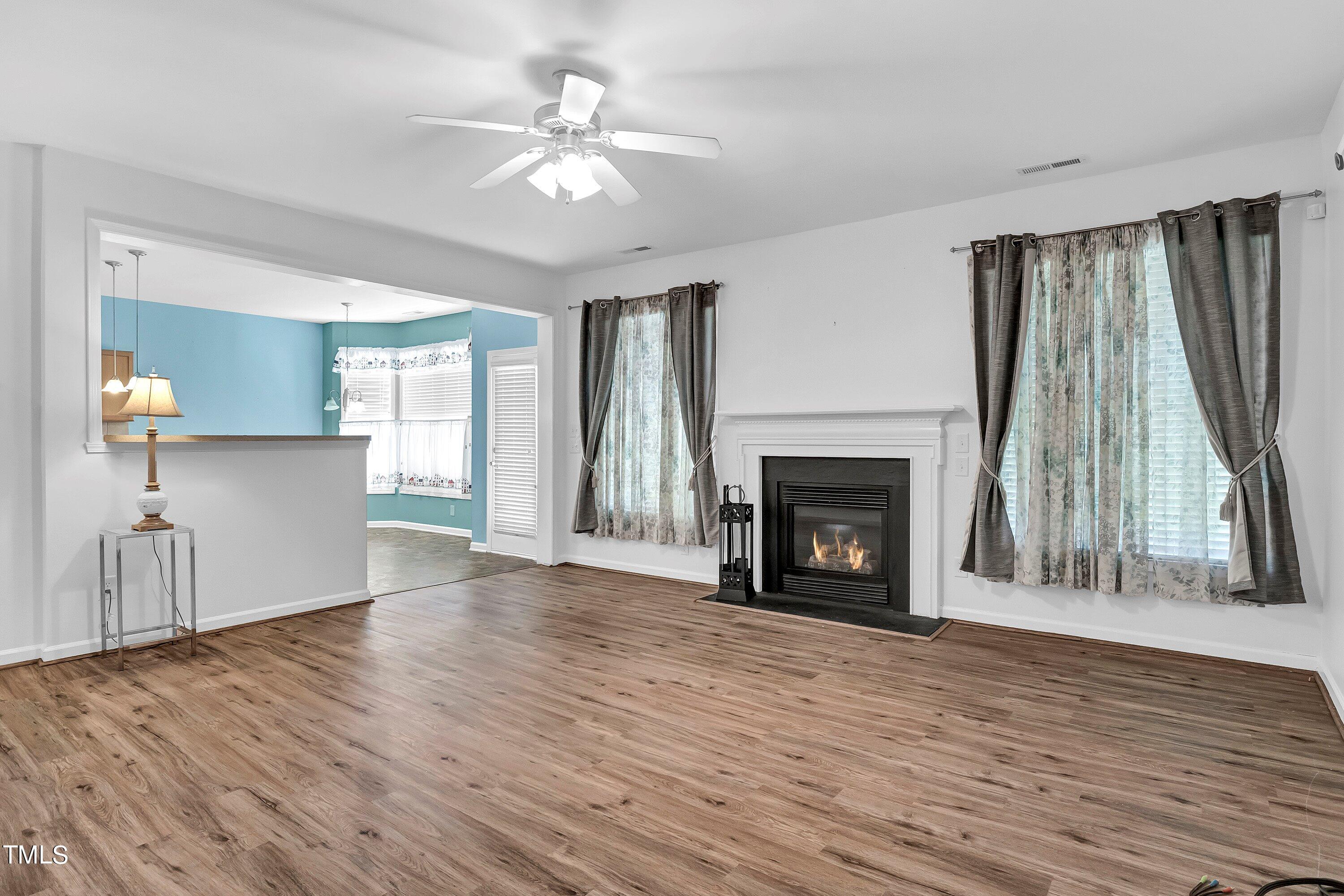 3932 Cane Garden Drive Raleigh, NC 27610 - Photo 16 of 34 a view of an empty room with wooden floor fireplace and a window