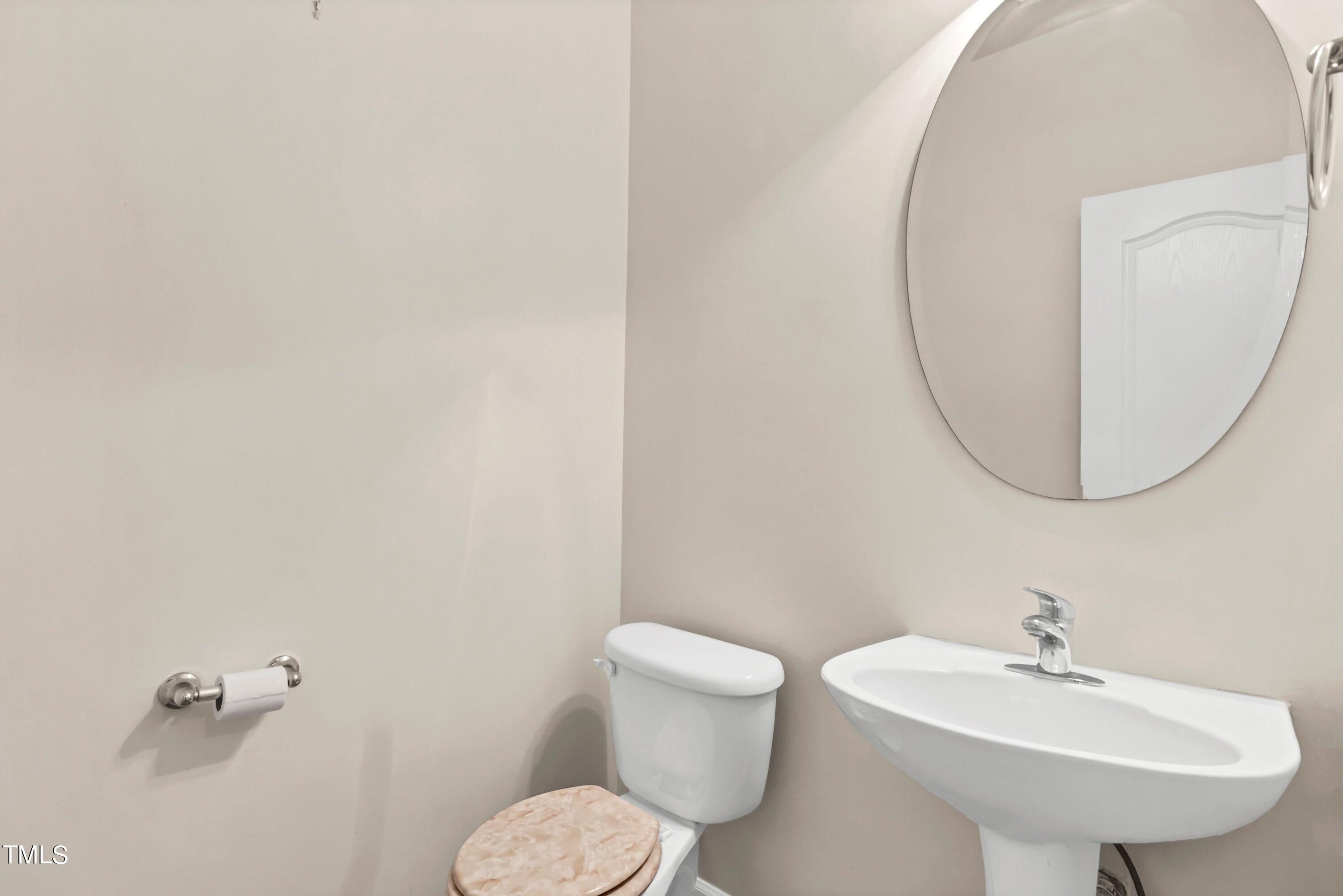 3932 Cane Garden Drive Raleigh, NC 27610 - Photo 18 of 34 a bathroom with a sink a mirror and a toilet