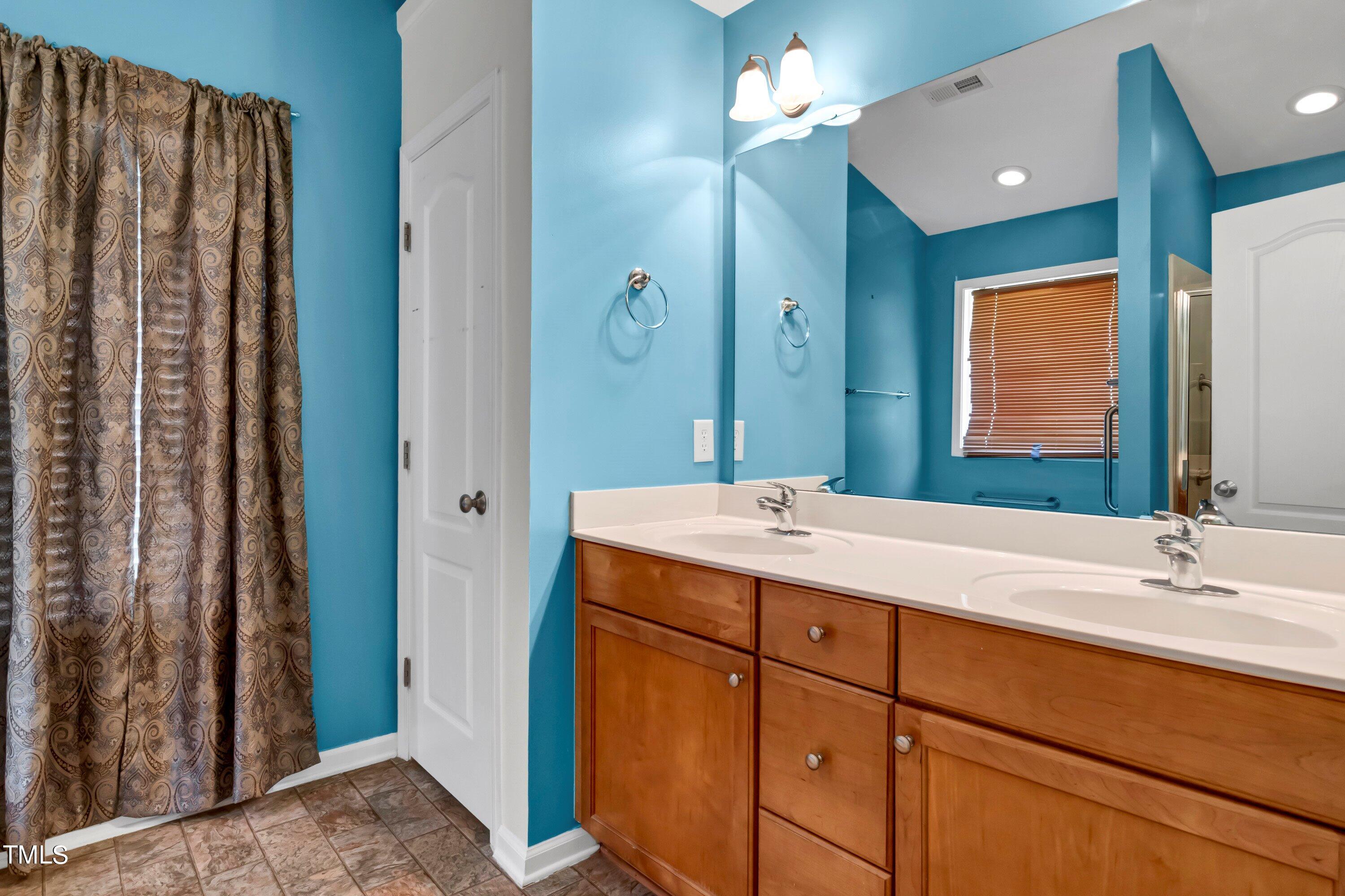 3932 Cane Garden Drive Raleigh, NC 27610 - Photo 22 of 34 a bathroom with a double vanity sink and a mirror