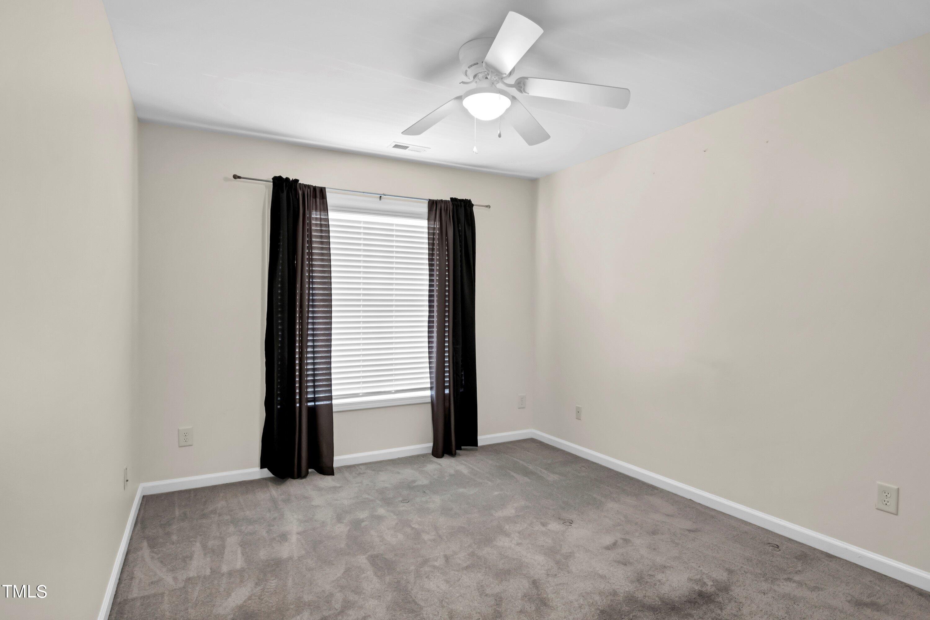 3932 Cane Garden Drive Raleigh, NC 27610 - Photo 27 of 34 an empty room with a ceiling fan and window