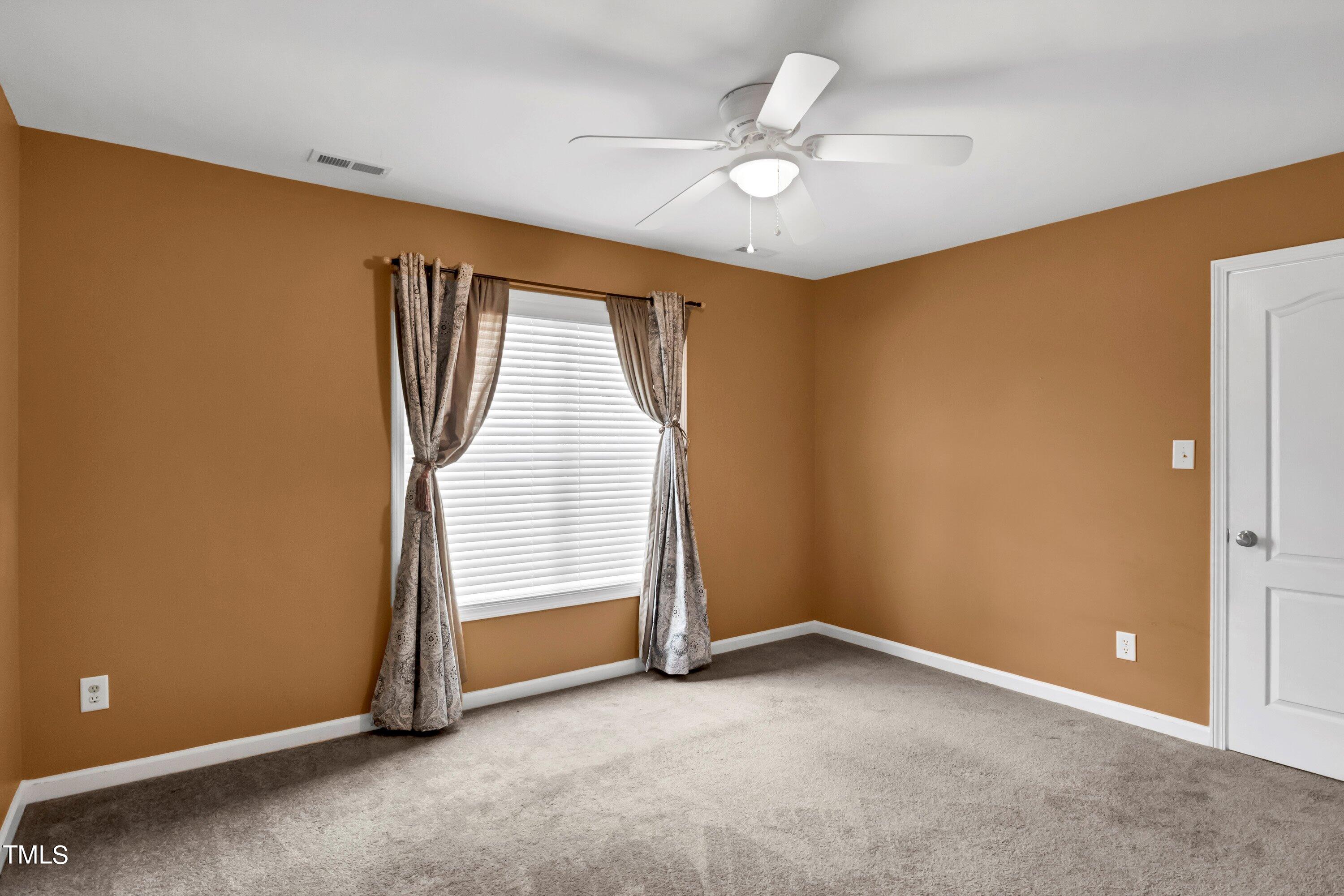 3932 Cane Garden Drive Raleigh, NC 27610 - Photo 29 of 34 an empty room with a ceiling fan and a window