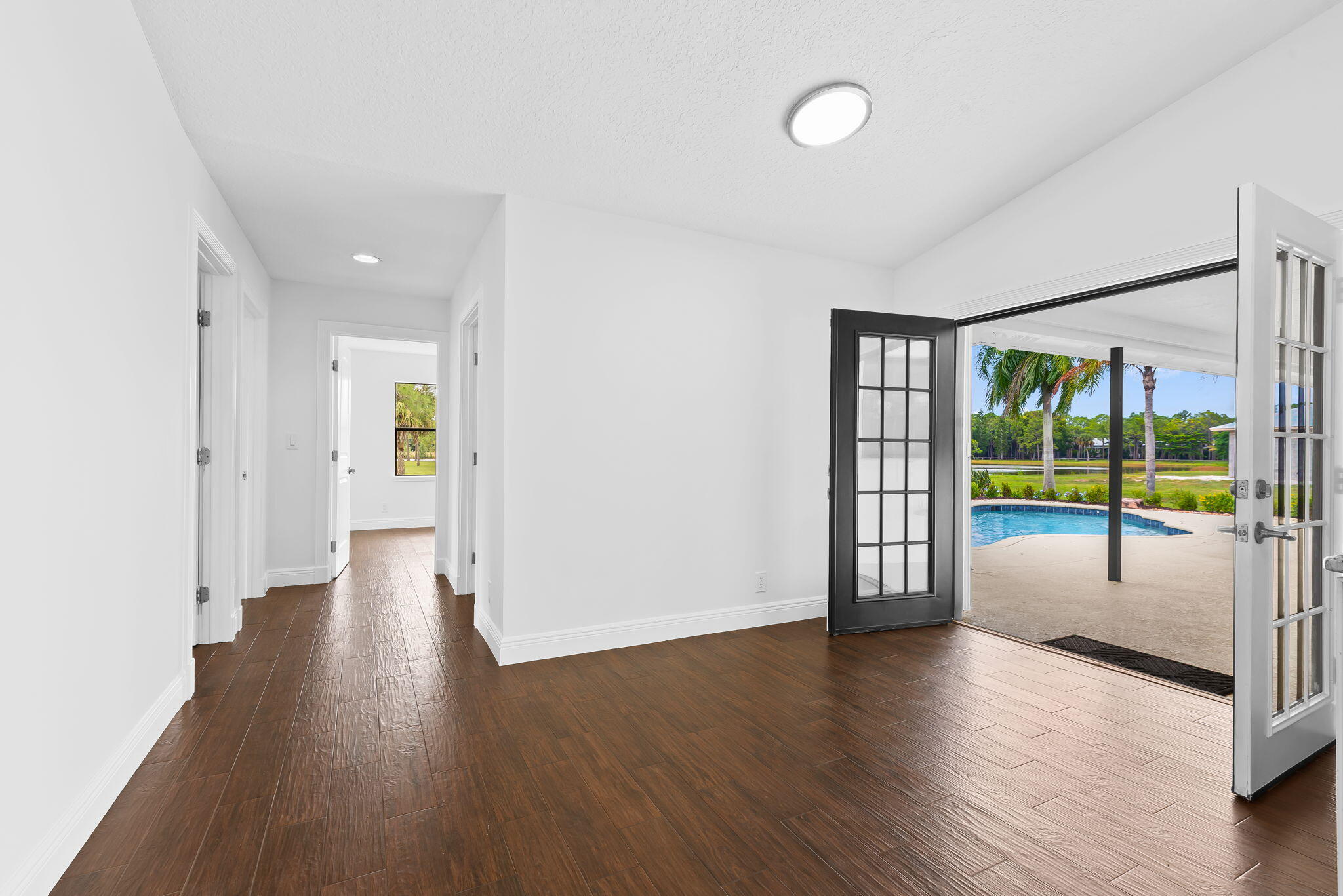 5635 Reynolds Road Lake Worth, FL 33449 - Photo 12 of 40 an empty room with wooden floor and windows