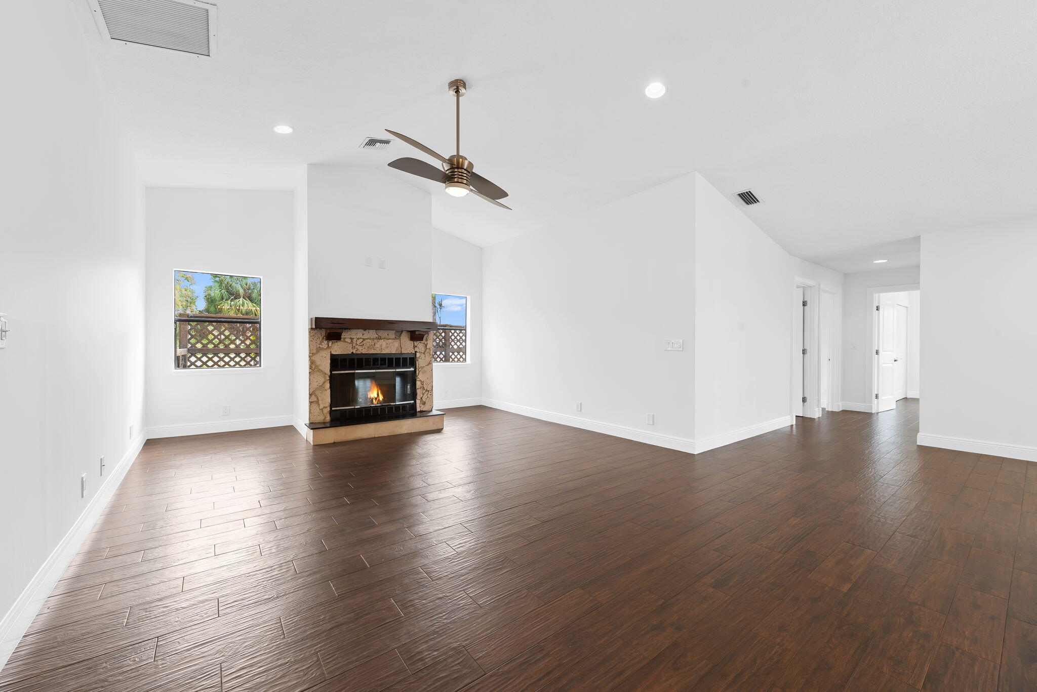 5635 Reynolds Road Lake Worth, FL 33449 - Photo 14 of 40 an empty room with wooden floor fireplace and windows