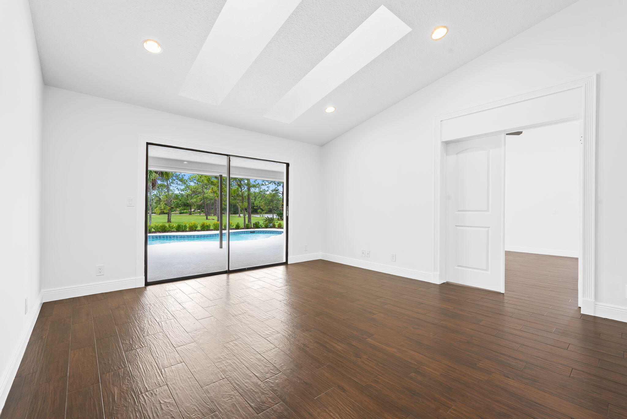 5635 Reynolds Road Lake Worth, FL 33449 - Photo 20 of 40 a view of an empty room with wooden floor and a window