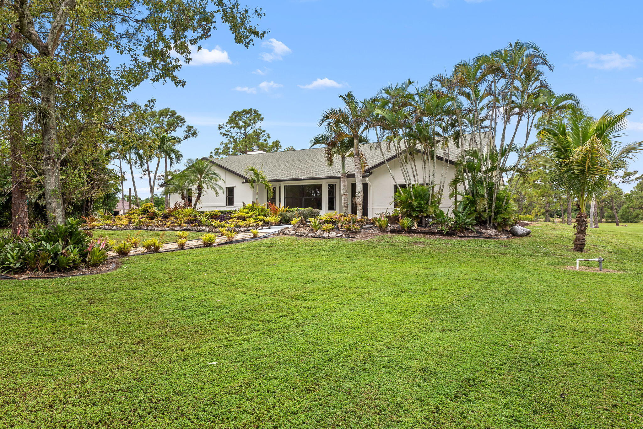 5635 Reynolds Road Lake Worth, FL 33449 - Photo 2 of 40 a front view of a building with a garden
