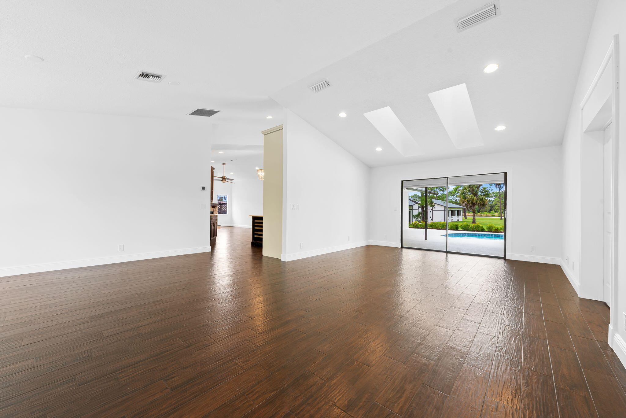 5635 Reynolds Road Lake Worth, FL 33449 - Photo 21 of 40 a view of an empty room with wooden floor and a window
