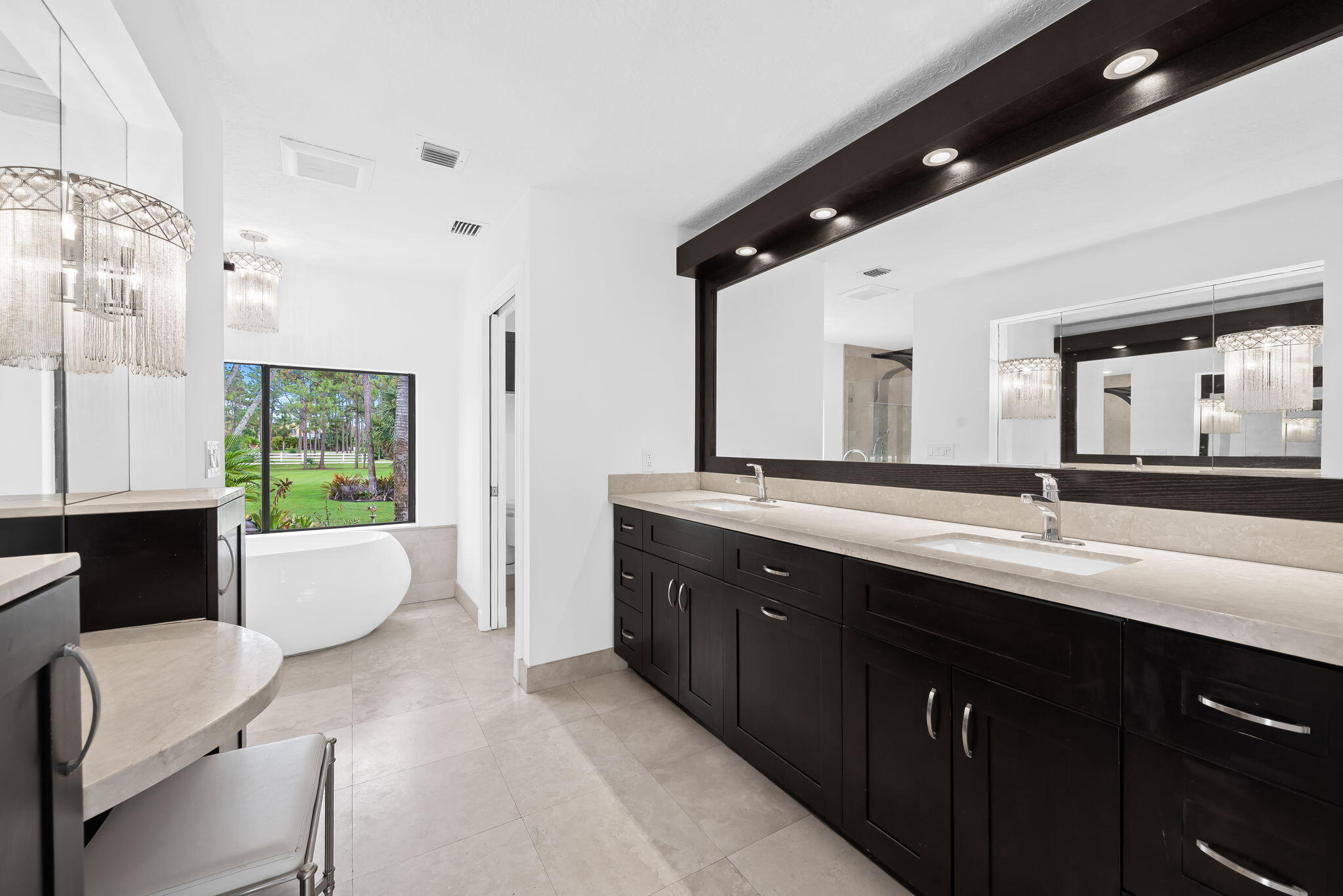 5635 Reynolds Road Lake Worth, FL 33449 - Photo 25 of 40 a spacious bathroom with a double vanity sink toilet mirror and bathtub