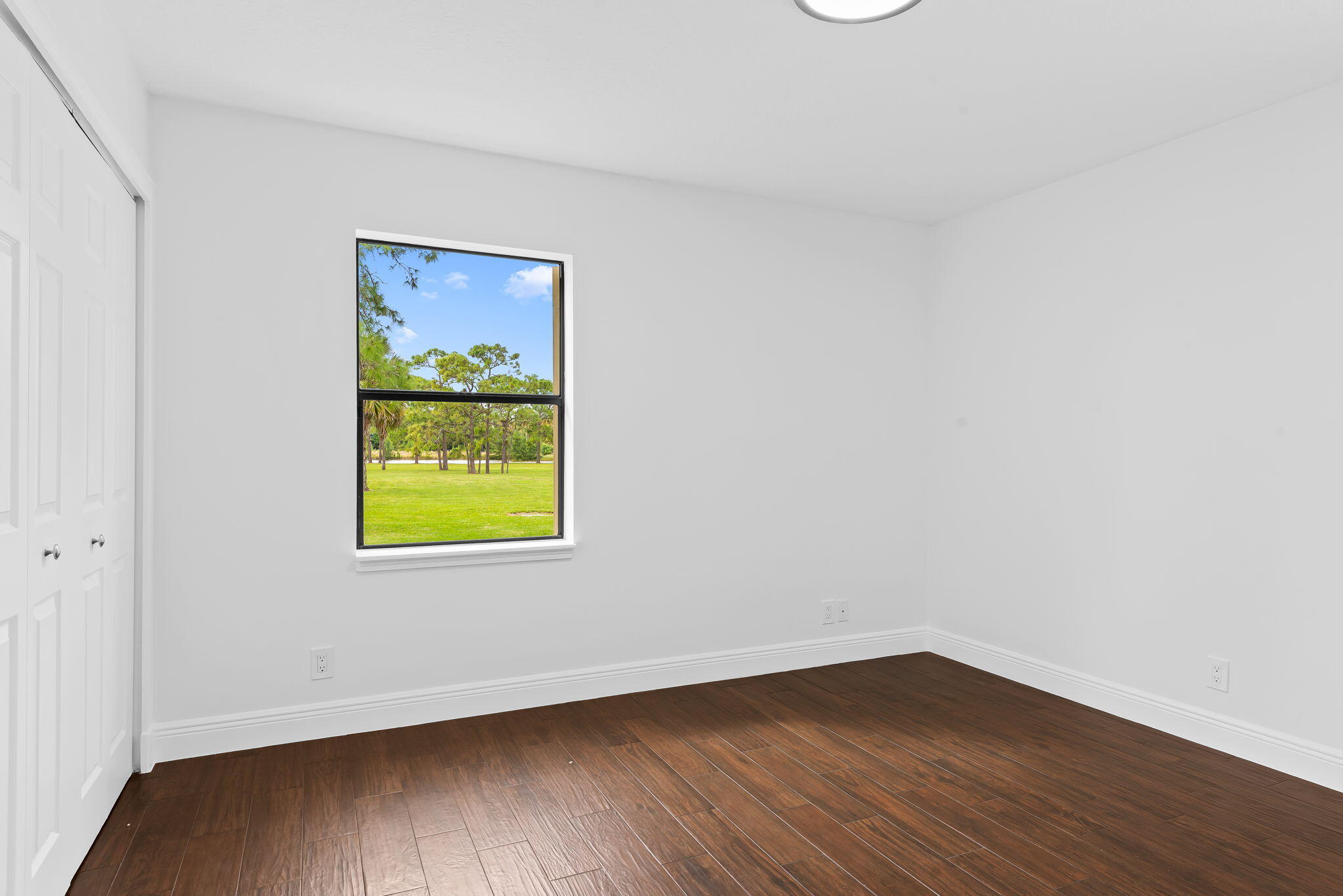 5635 Reynolds Road Lake Worth, FL 33449 - Photo 28 of 40 a view of an empty room with wooden floor and a window