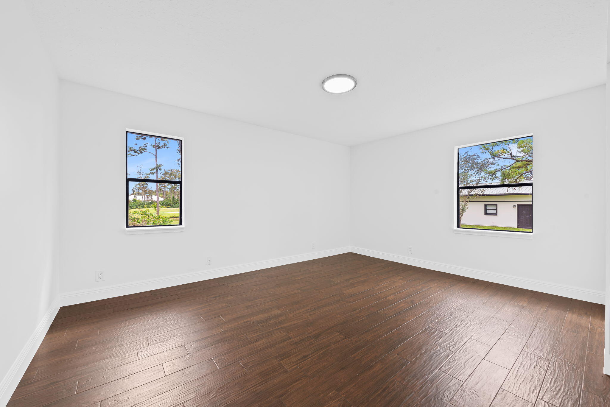 5635 Reynolds Road Lake Worth, FL 33449 - Photo 29 of 40 a view of an empty room with wooden floor and a window