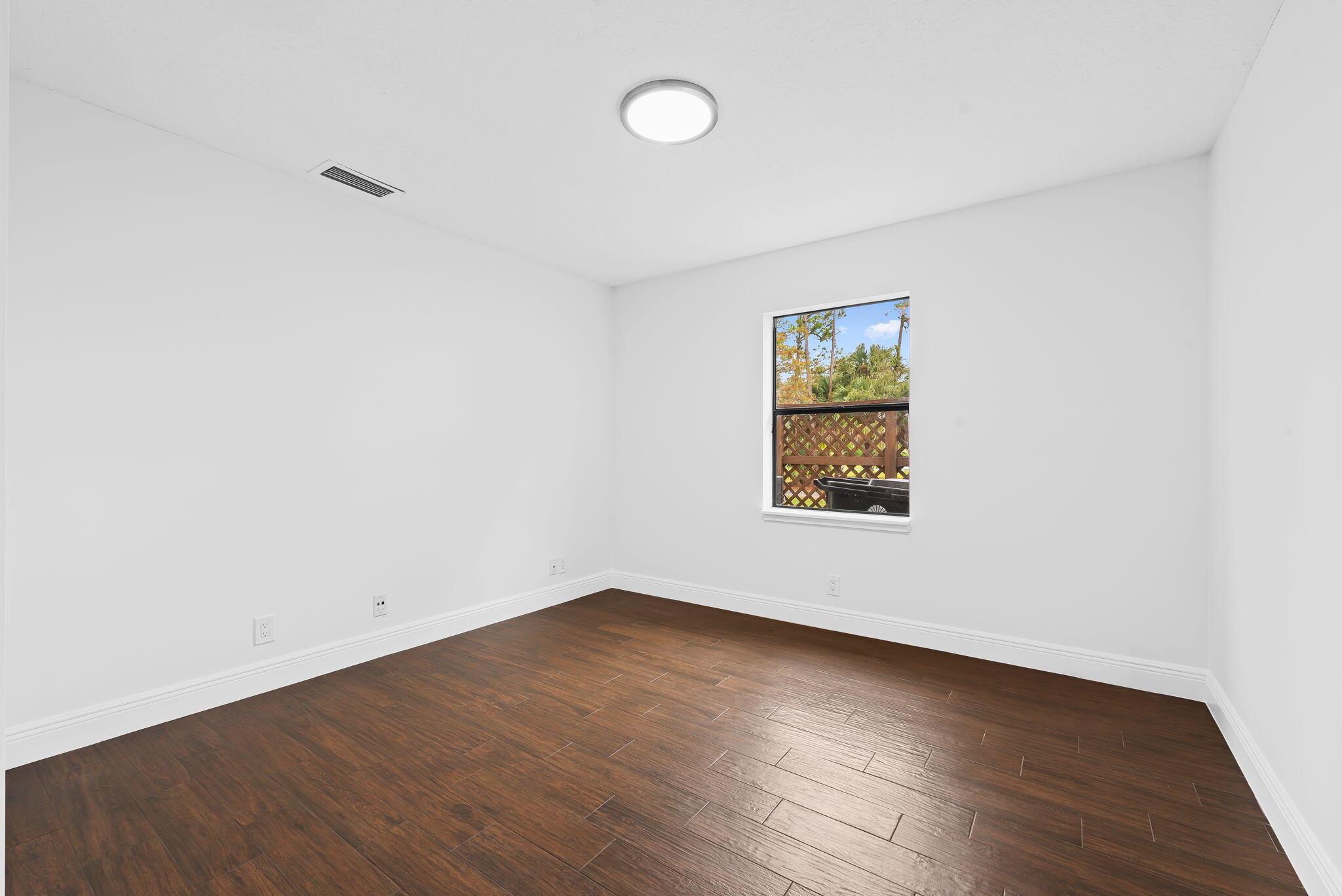 5635 Reynolds Road Lake Worth, FL 33449 - Photo 30 of 40 an empty room with wooden floor and windows