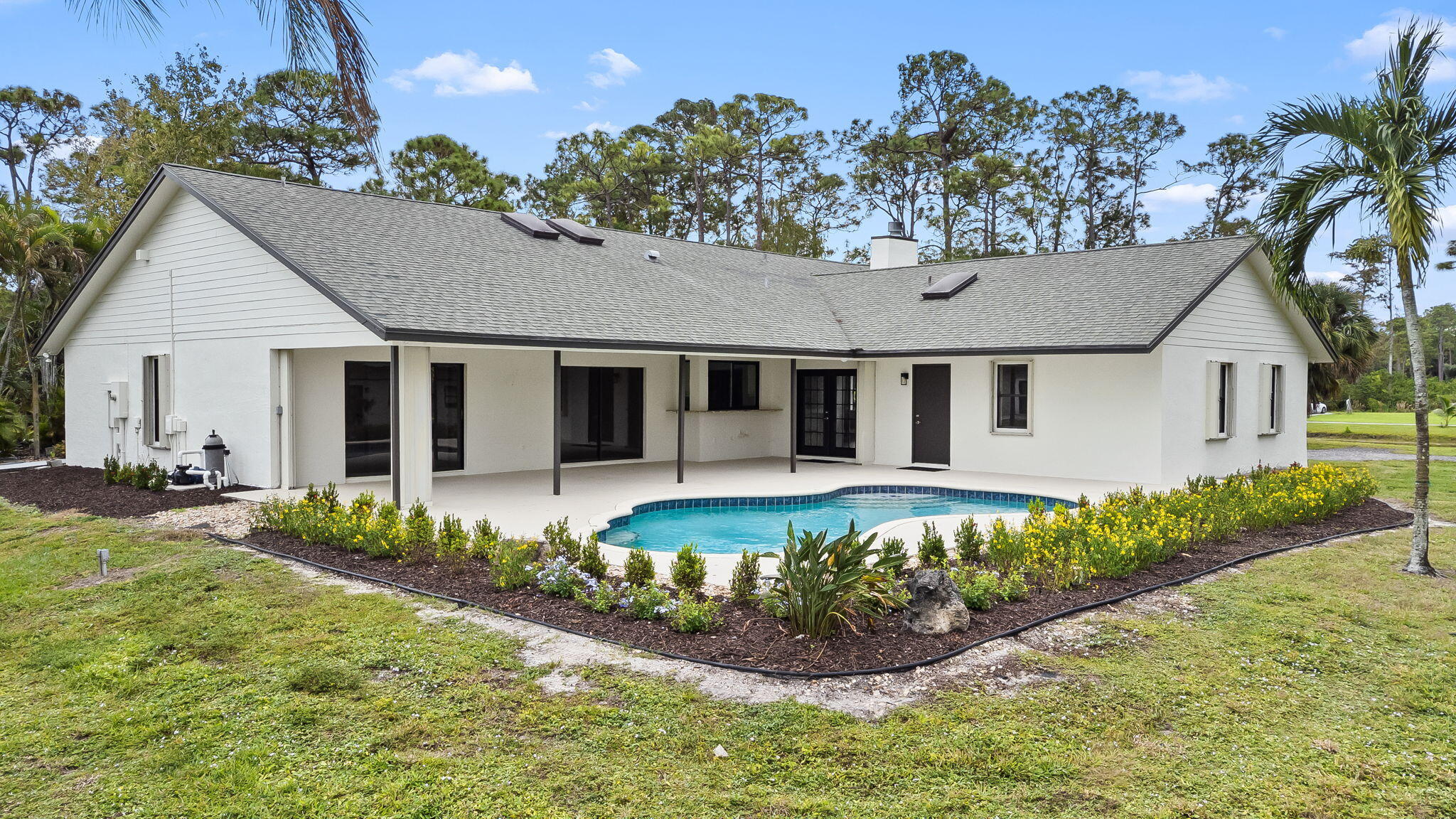 5635 Reynolds Road Lake Worth, FL 33449 - Photo 4 of 40 a front view of a house with a yard and outdoor seating