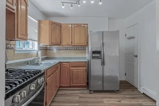 a kitchen with stainless steel appliances granite countertop a refrigerator and a stove top oven