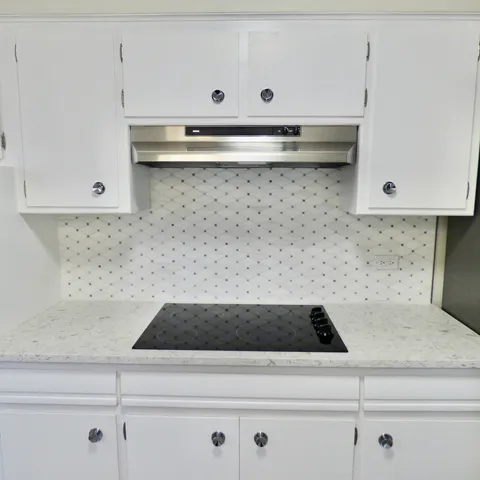 a kitchen with white cabinets and appliances