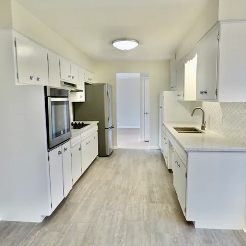 a kitchen with appliances a sink and cabinets