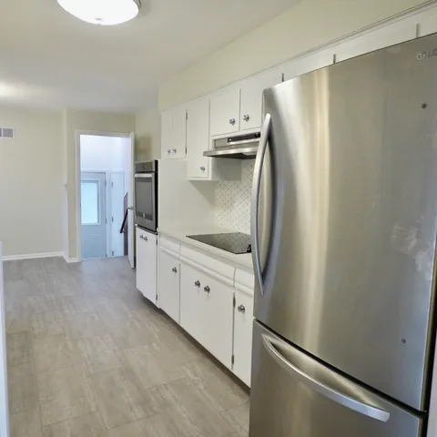 a kitchen with white cabinets and stainless steel appliances