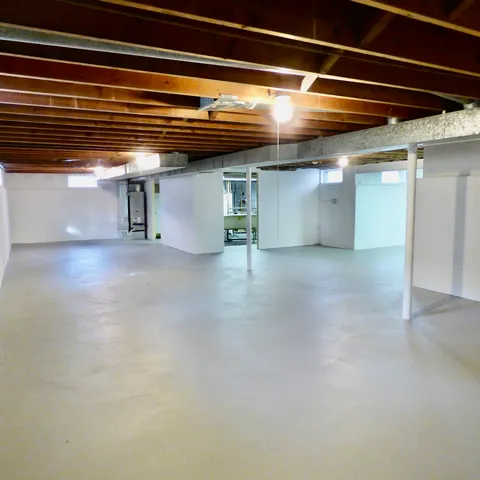 a view of empty room with wooden floor and windows