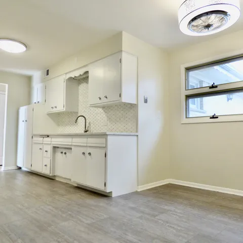 a spacious bathroom with a granite countertop sink and a mirror