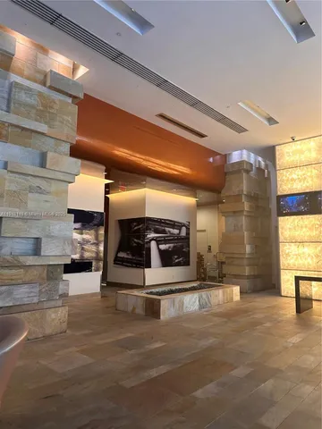 a view of a living room with a floor to ceiling window and wooden floor