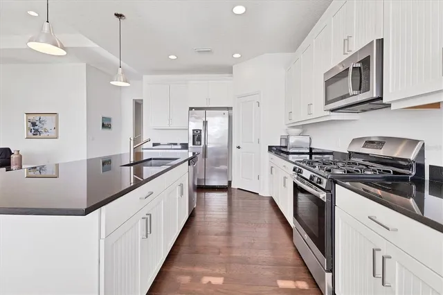 a large kitchen with stainless steel appliances granite countertop a stove a sink dishwasher and a refrigerator