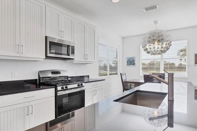a kitchen with granite countertop a sink stove and cabinets