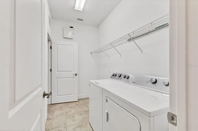 a utility room with cabinets washer and dryer