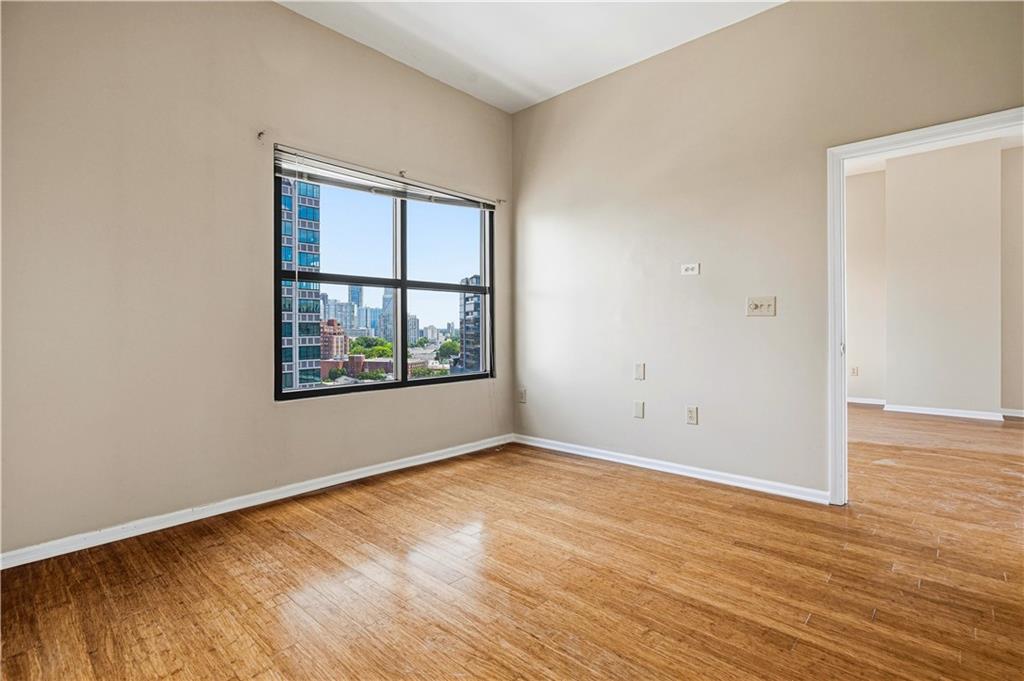 3040 Peachtree Road Northwest, Unit 1503 Atlanta, GA 30305 - Photo 15 of 38 a view of an empty room with wooden floor and a window