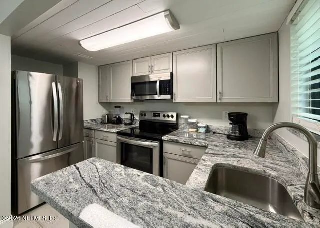 a kitchen with stainless steel appliances granite countertop a stove a sink dishwasher a refrigerator and a microwave oven