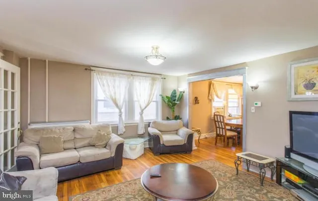 a living room with furniture a flat screen tv and a large window