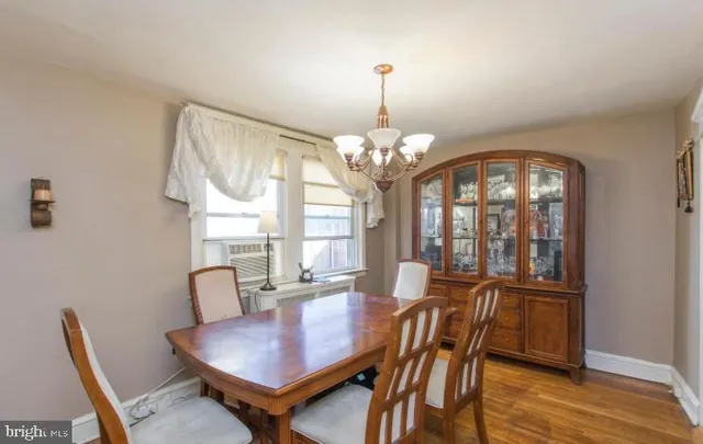 a view of a dining room with furniture a chandelier and wooden floor