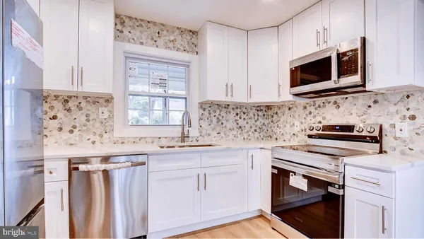 a kitchen with stainless steel appliances a stove microwave and cabinets