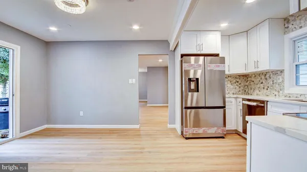 a view of kitchen with stainless steel appliances granite countertop cabinets and wooden floor