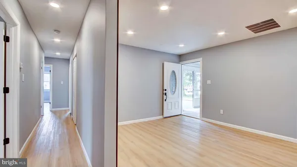 a view of hallway with livingroom and wooden floor