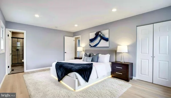 a bedroom with a bed and painting on the wall