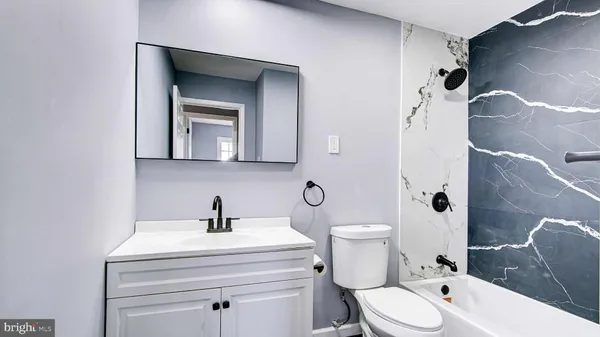 a bathroom with a toilet sink and mirror