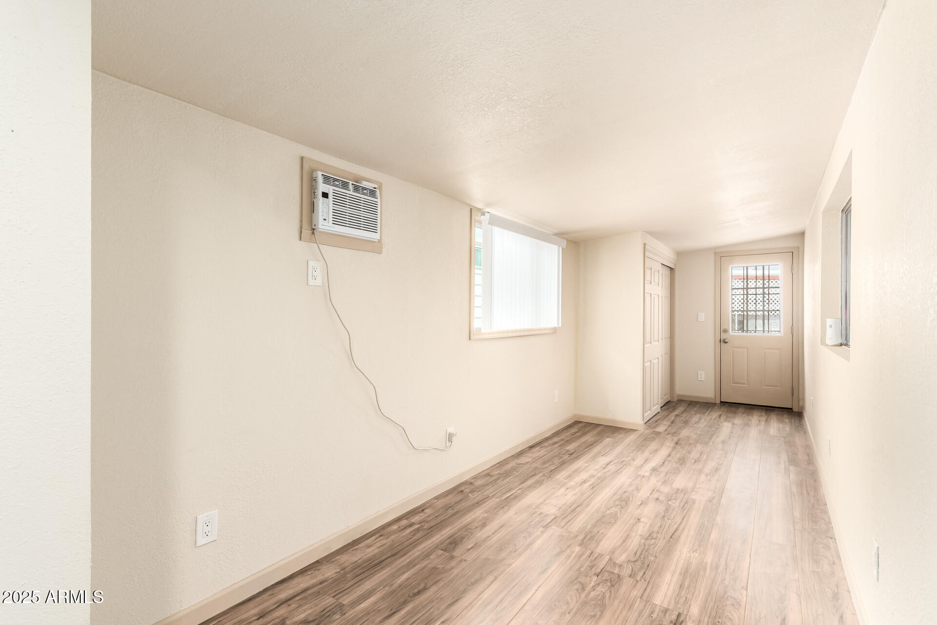 2050 West Dunlap Avenue, Unit R434 Phoenix, AZ 85021 - Photo 21 of 26 a view of an empty room with wooden floor and a window