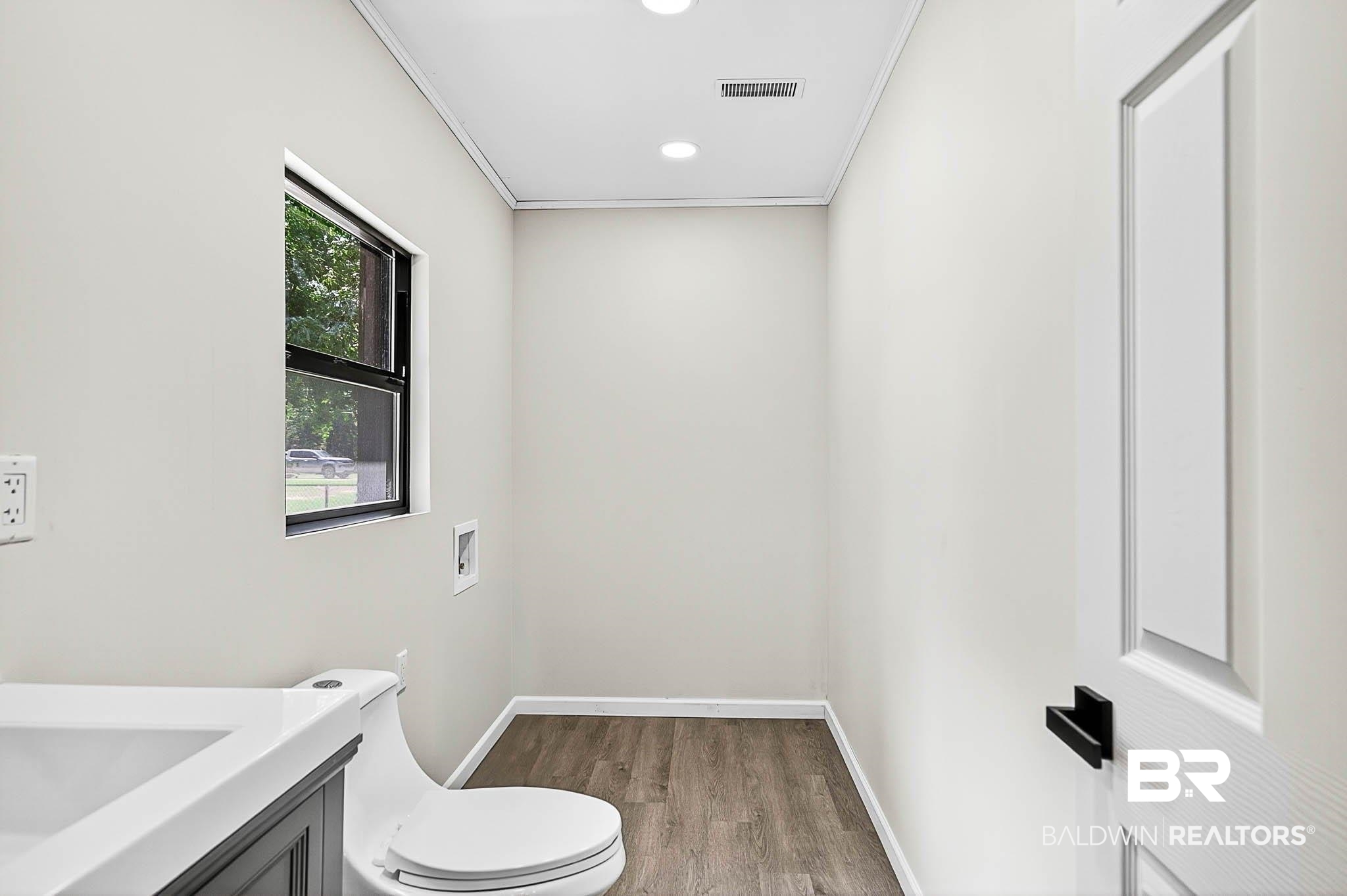 101 Terry Avenue Brewton, AL 36426 - Photo 40 of 48 Half bathroom featuring vanity, wood finished floors, ornamental molding, and recessed lighting