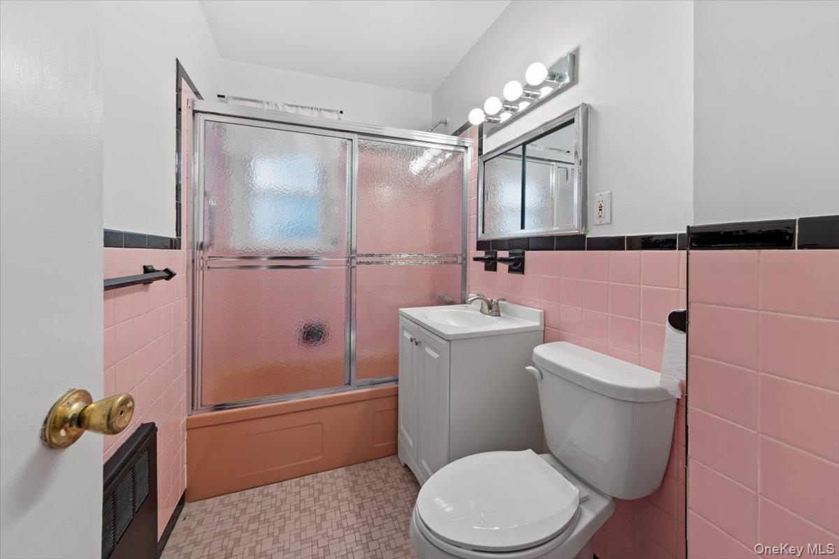 5824 Fieldston Road Bronx, NY 10471 - Photo 11 of 27 a bathroom with a toilet sink vanity and shower