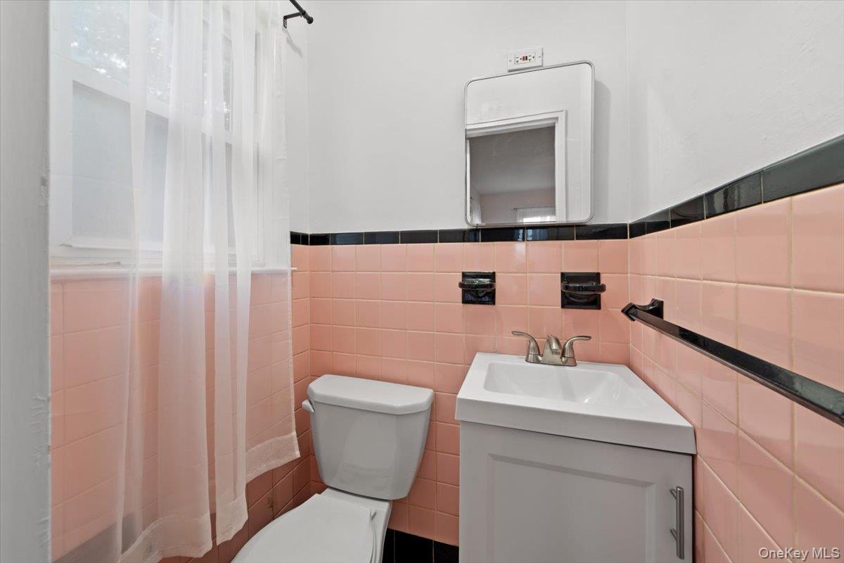 5824 Fieldston Road Bronx, NY 10471 - Photo 13 of 27 a bathroom with a sink a toilet and mirror