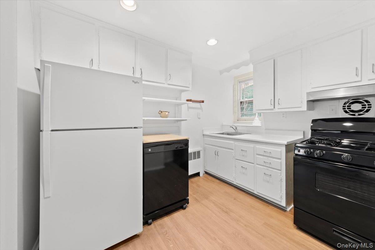 5824 Fieldston Road Bronx, NY 10471 - Photo 22 of 27 a kitchen with a refrigerator stove and white cabinets