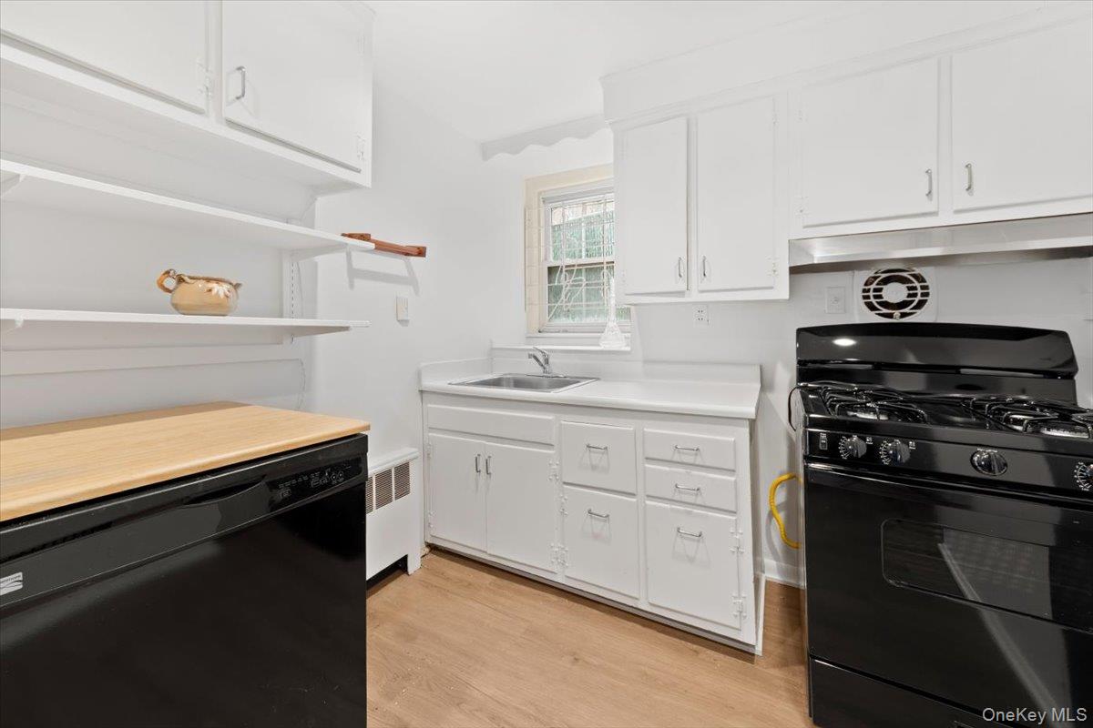 5824 Fieldston Road Bronx, NY 10471 - Photo 23 of 27 a kitchen with white cabinets and appliances