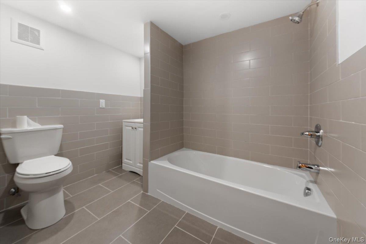 5824 Fieldston Road Bronx, NY 10471 - Photo 24 of 27 a white bath tub sitting next to a white toilet and a sink