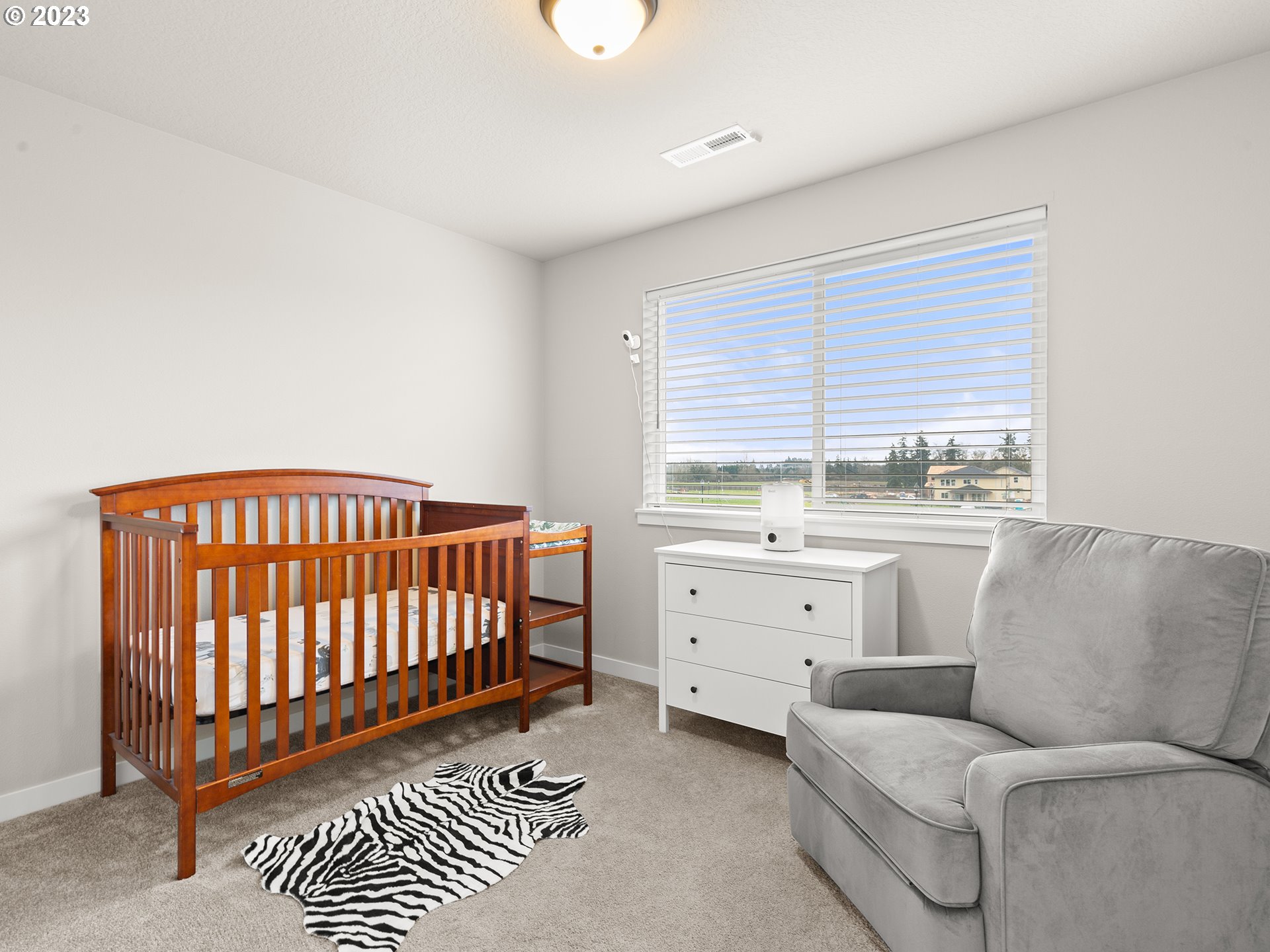 8713 North 1st Street Ridgefield, WA 98642 - Photo 19 of 24 a living room with furniture a baby crib and a window
