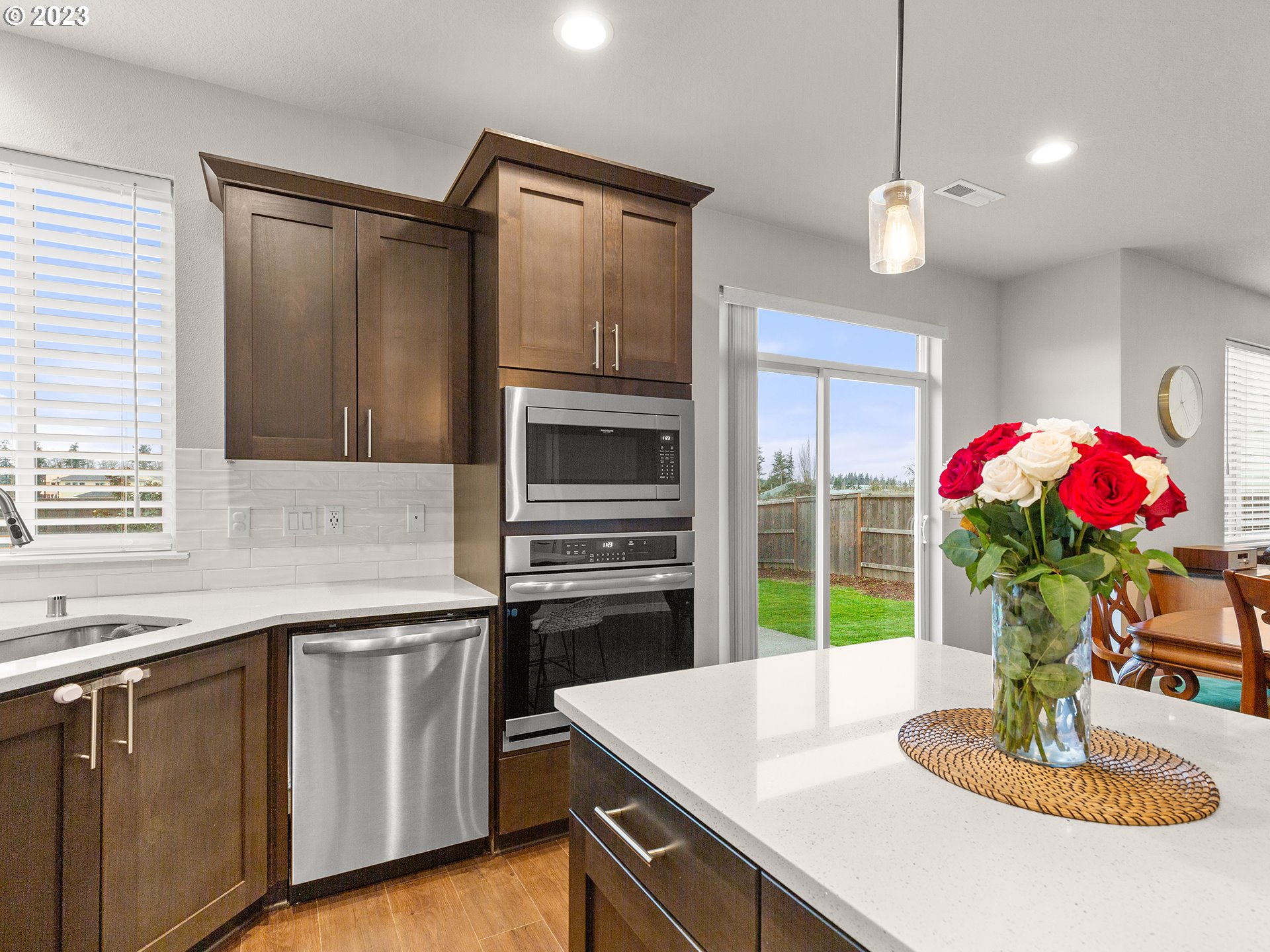 8713 North 1st Street Ridgefield, WA 98642 - Photo 6 of 24 a kitchen with stainless steel appliances kitchen island granite countertop a refrigerator a sink dishwasher with a dining table and chairs