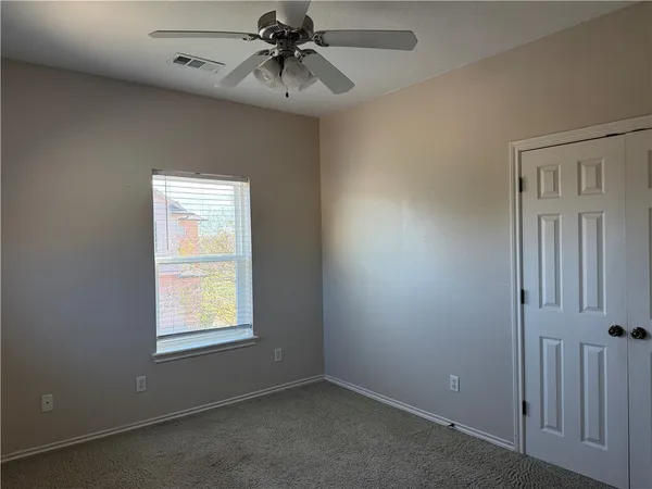 an empty room with a window and a fan