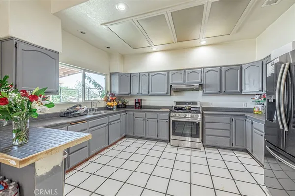 a kitchen with a sink window and stainless steel appliances