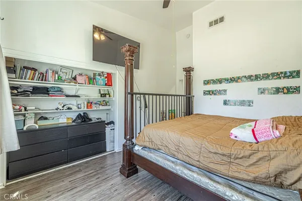 a bedroom with a bed and a flat tv screen on dresser