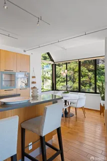 a kitchen with stainless steel appliances a large counter top space a sink a stove and a window