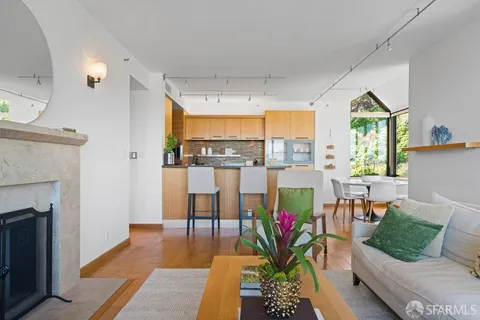 a living room with furniture a fireplace and a floor to ceiling window