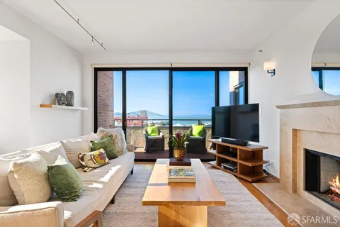 a view of a living room with a large window and potted plants
